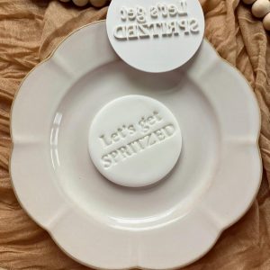 8cm fondant stamp with the phrase ‘Let’s Get Spritzed’ in playful font